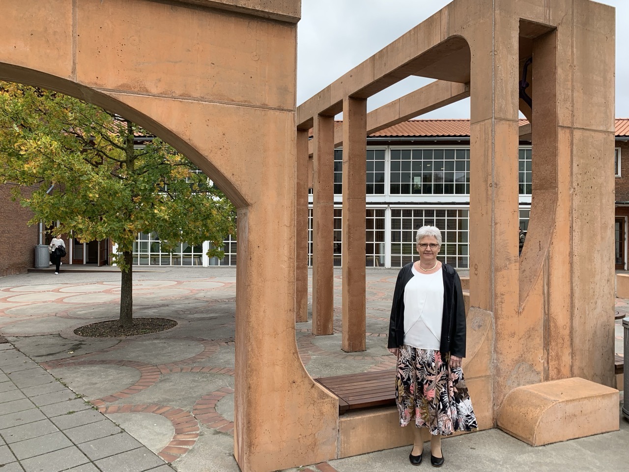 Rektor Anne Frausing foran det værk, som kunstneren FOS har skabt til HF-Centret Efterslægten. 